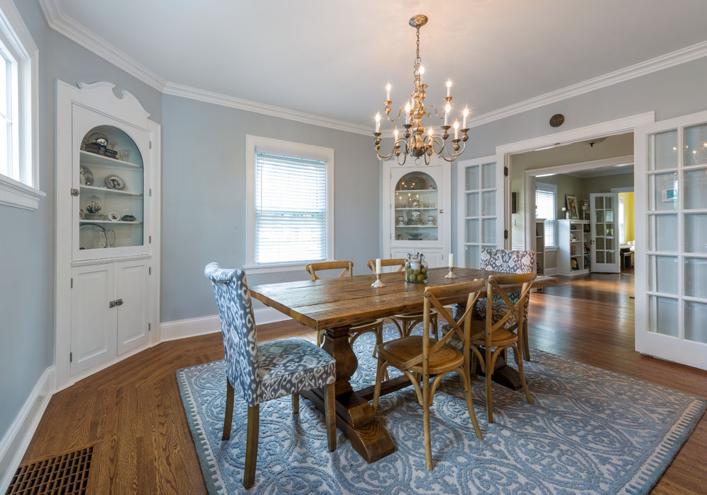 Octagonal dining room with wood floor, white trim and build-ins and gray walls